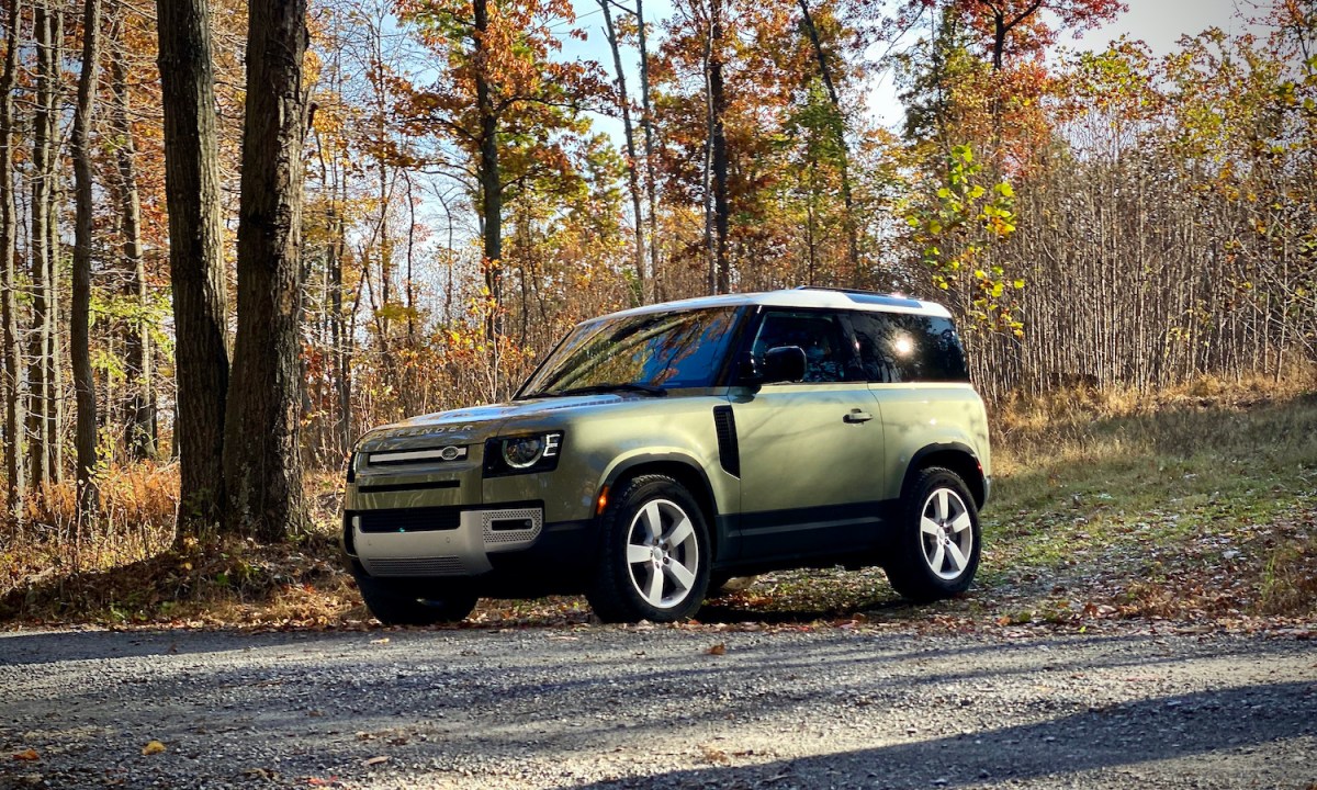 Land Rover Defender 90 front driver's side in front of trees.