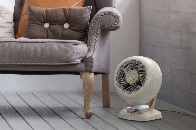 A space heater beside an armchair in a living room.