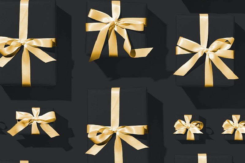 Presents wrapped in black gift wrapper and golden ribbon lace.