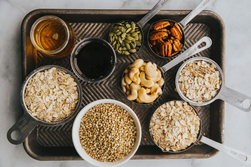 nuts, oats, oils, and various gluten free food on a tray.