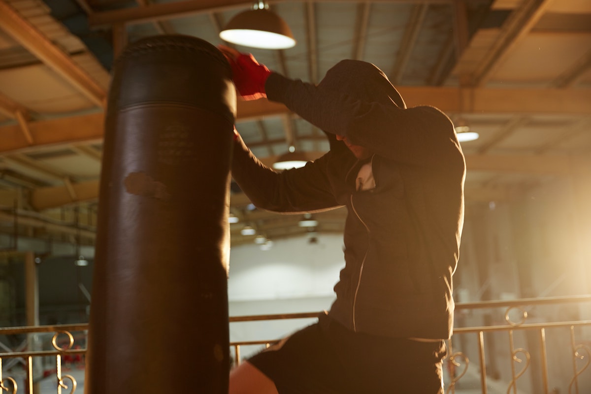 man kneeing a punching bag.