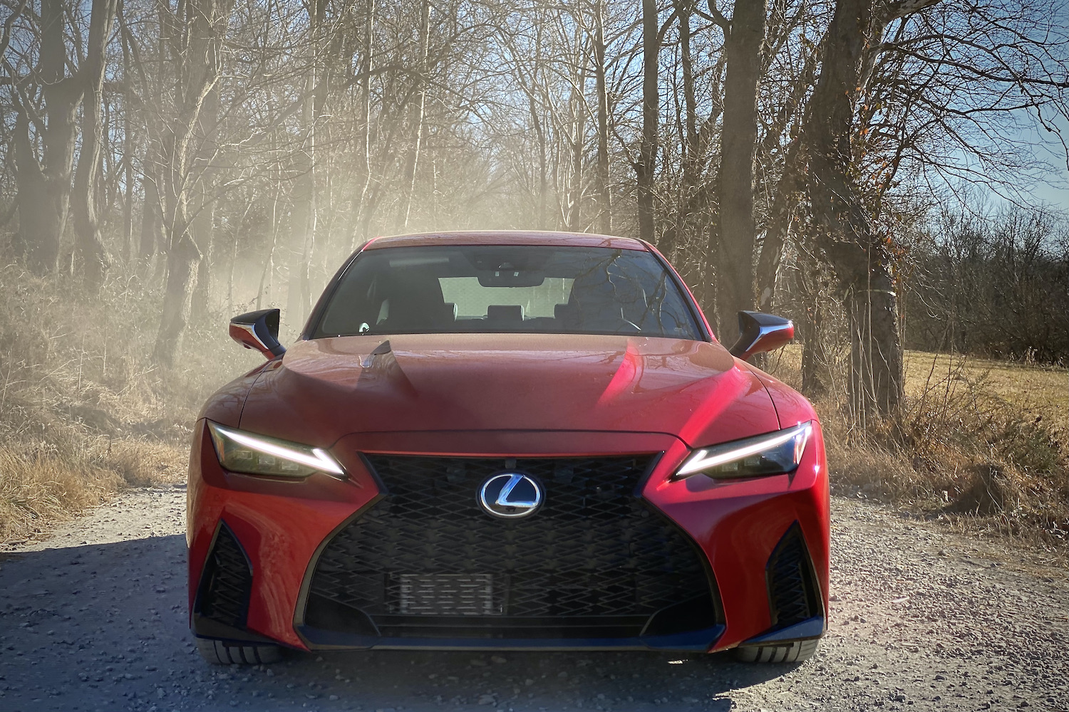 Lexus IS 500 front end on a gravel road with dust in the back.