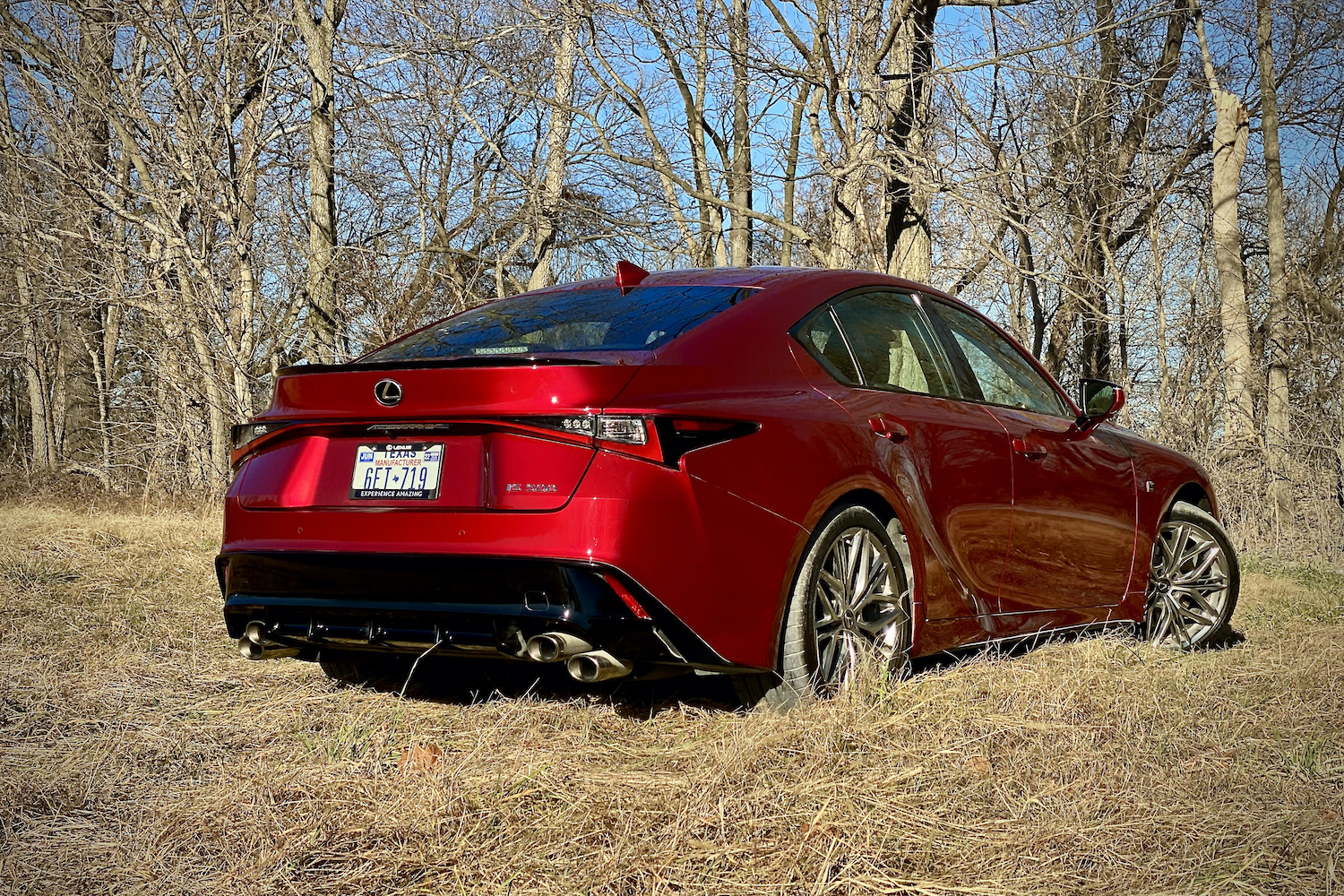 Lexus IS 500 rear end from passenger's side in a grassy field.