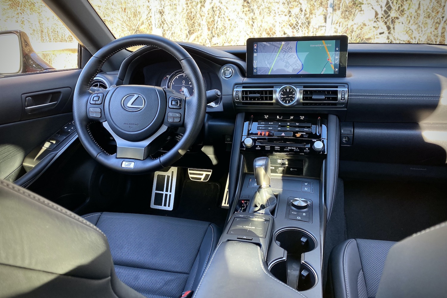 Lexus IS 500 dashboard from passenger's side rear seats with trees in the back.