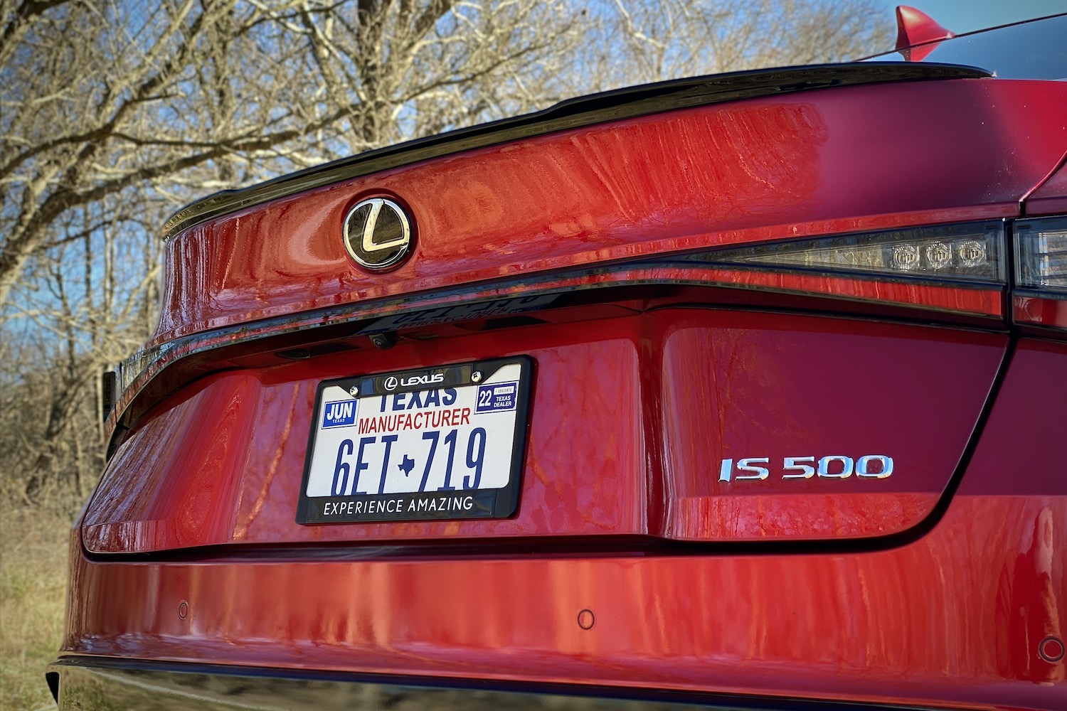 Close up of Lexus IS 500 rear trunk in front of trees.