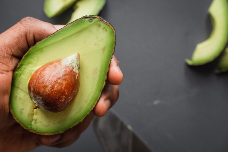 Aguacate en la mano de alguien.