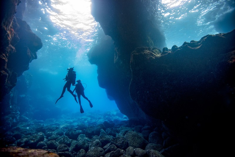 Two divers in an underwater cavern.