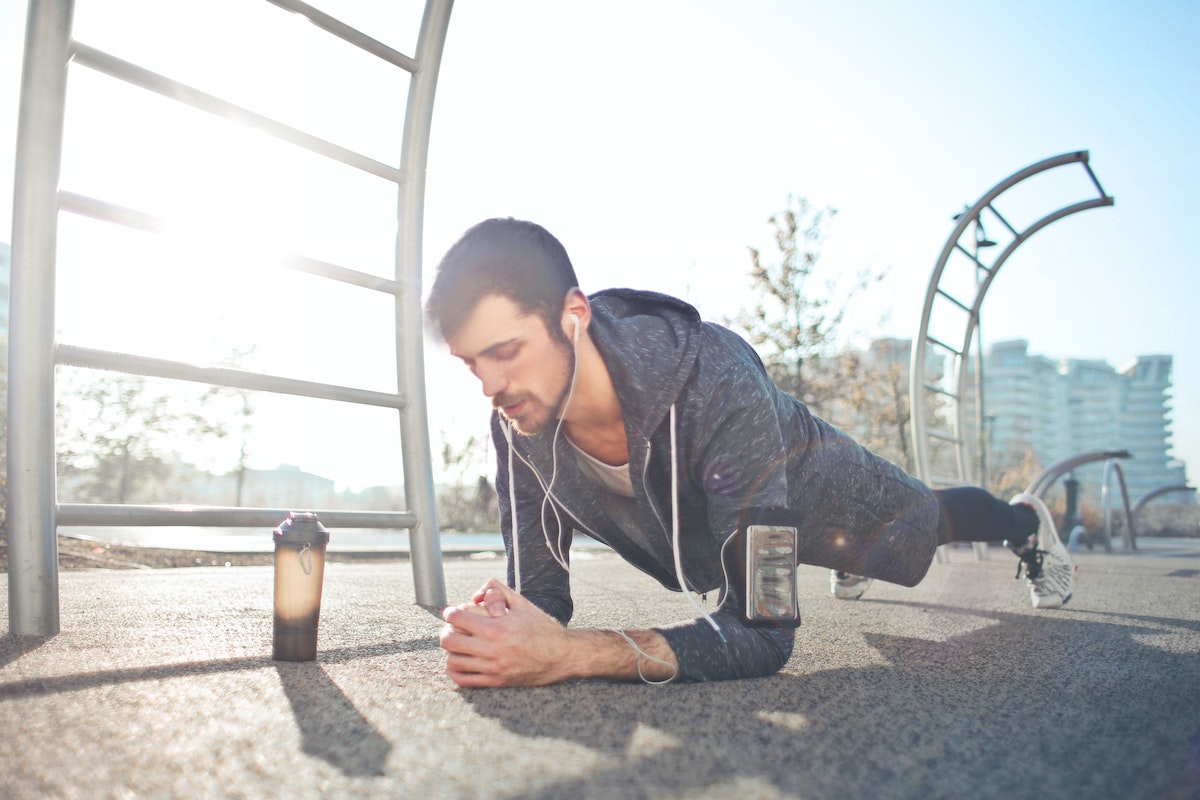 Man doing plank with pre-workout supplement