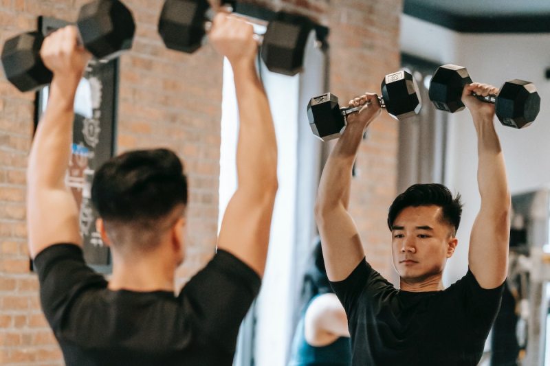 Man lifting weights by mirror