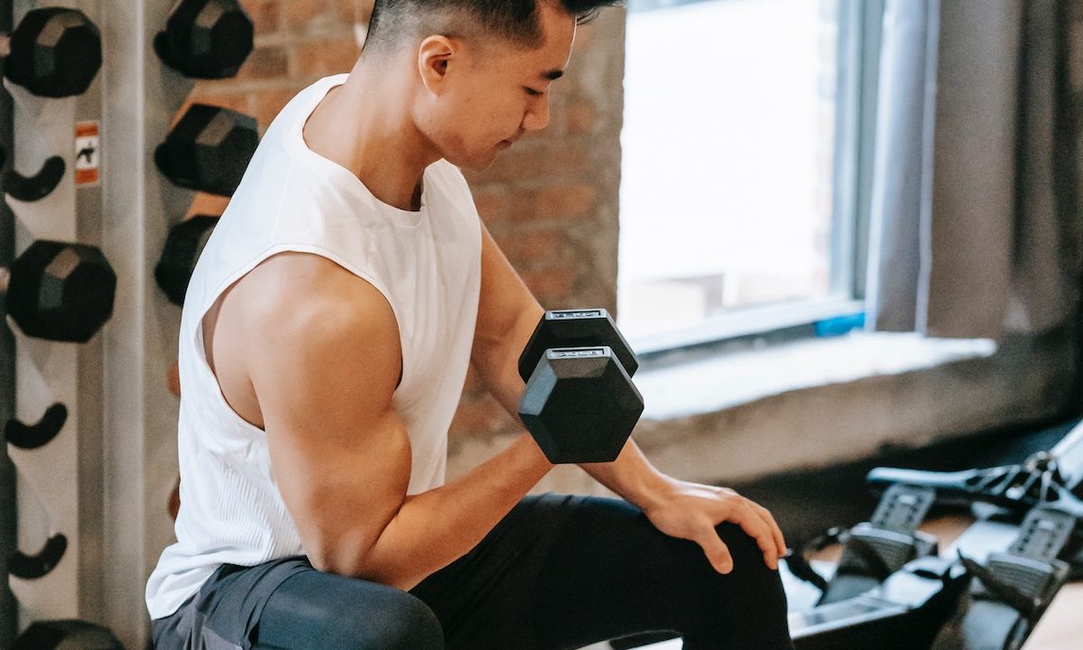 Man doing concentration curls white shirt