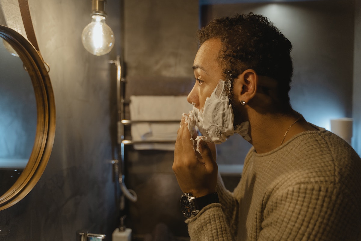 Man shaving in the mirror.