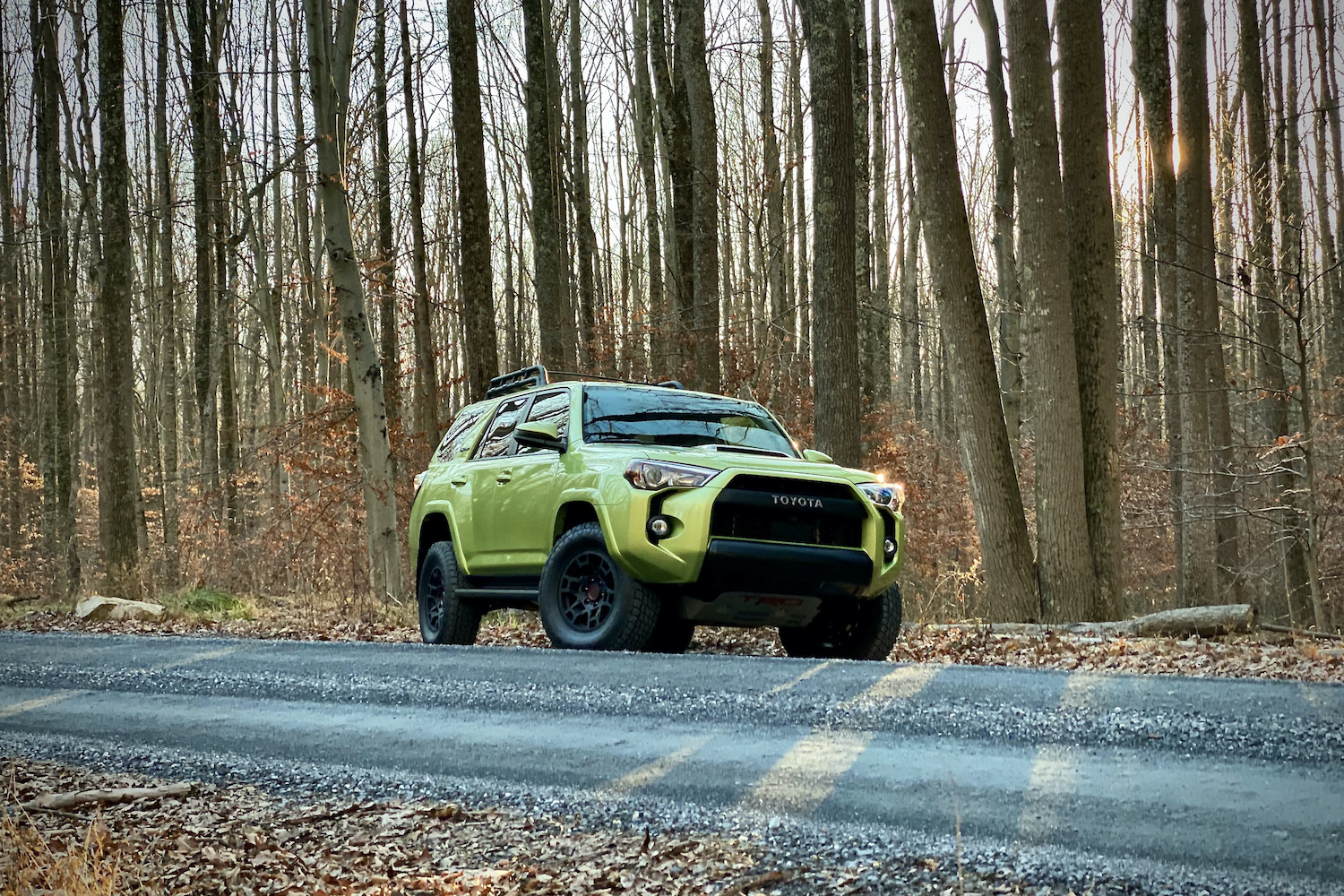 Front end of Toyota 4Runner TRD Pro on a gravel path in front of trees.