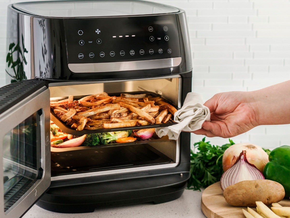 The Bella Pro Series air fryer oven with fries and vegetables being cooked.