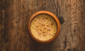 Small clay cup of Indian chai on a wooden table.
