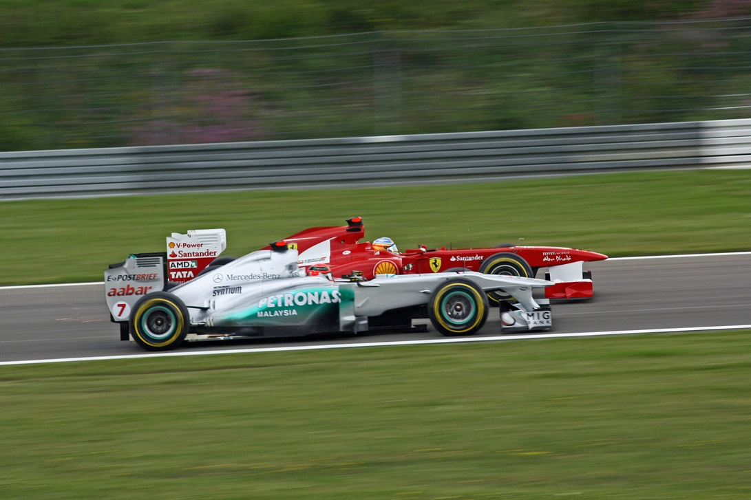 Two formula 1 race cars passing each other.