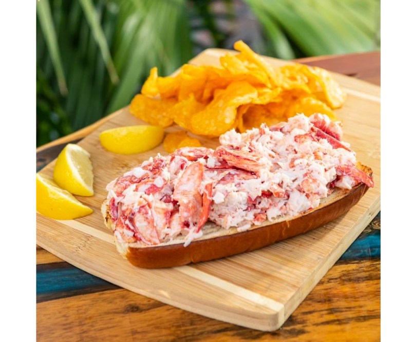 Lobster and chips on cutting board.