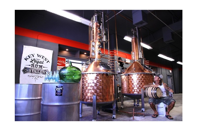 Distiller sits beside copper stills at Key West Distillers.