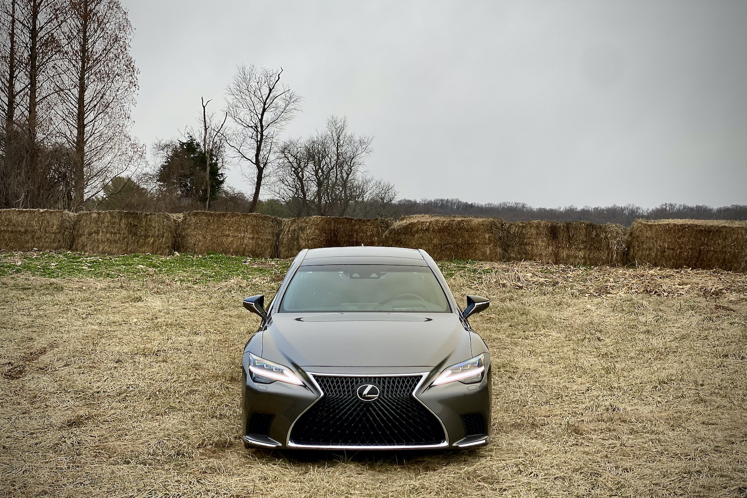 The 2021 Lexus LS500's front end in a field with hay bales in the back.