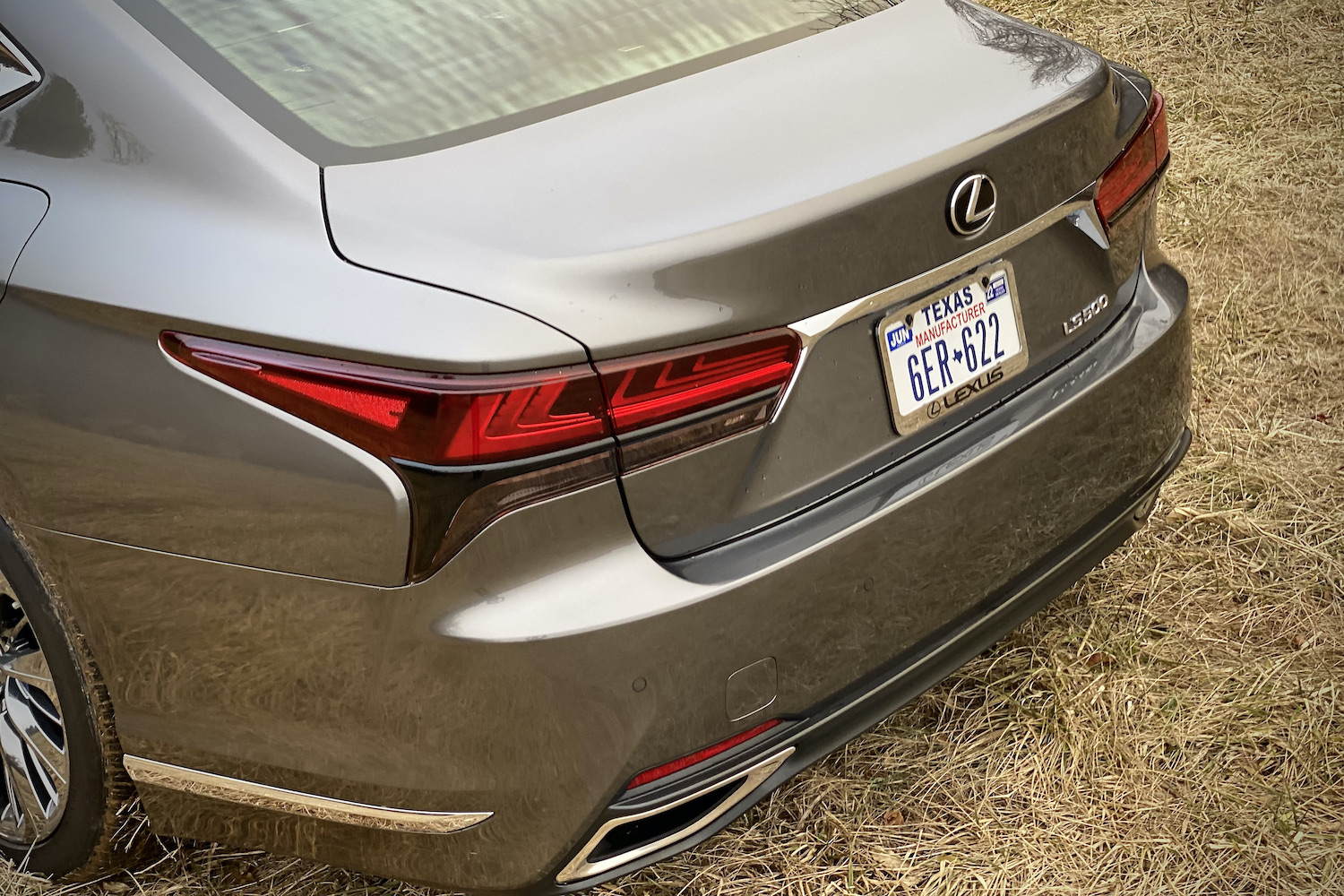 A close-up of the 2021 Lexus LS500's taillight in a grassy field.