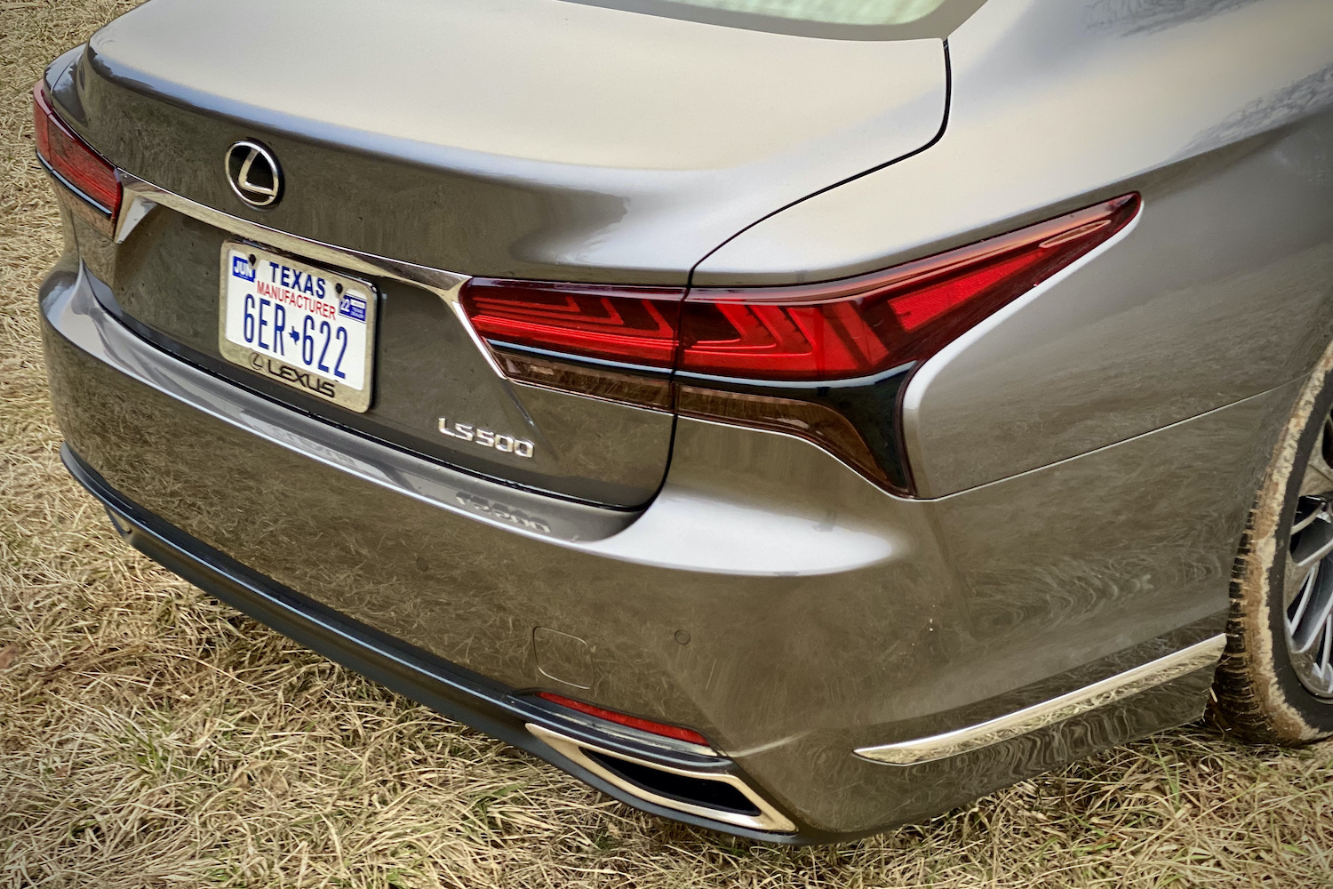 A close-up of the 2021 Lexus LS500's taillight in a grassy field.
