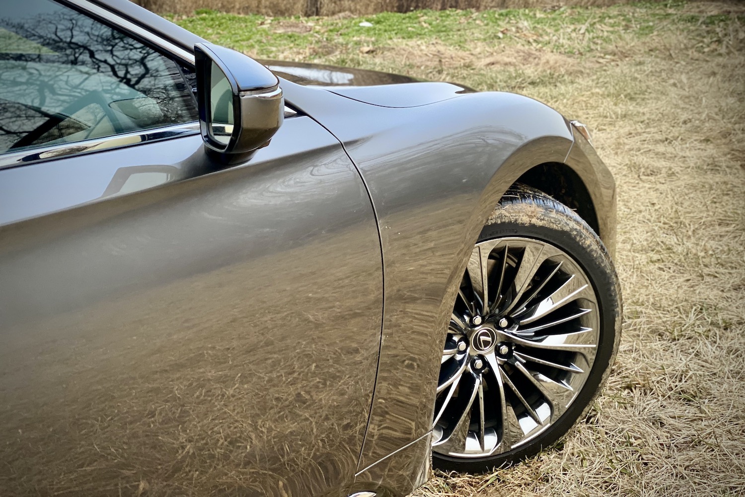 The front wheel on the 2021 Lexus LS500 in a grassy field.