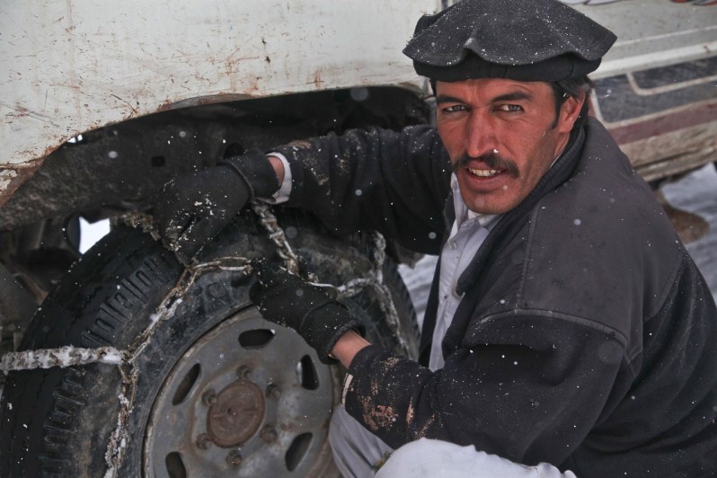 Man putting on snow chains