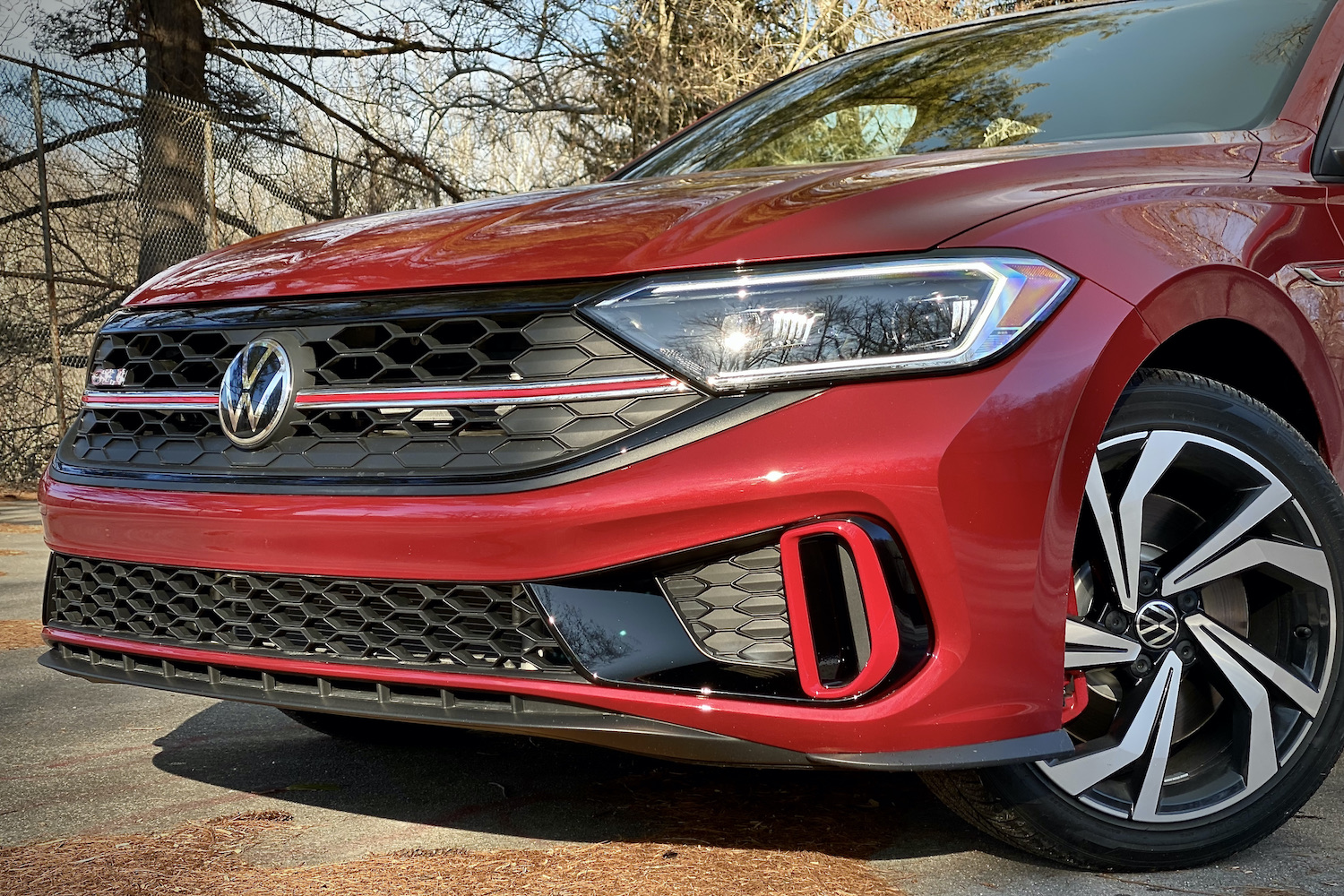 Close up of 2022 Volkswagen Jetta front end with trees in the background.