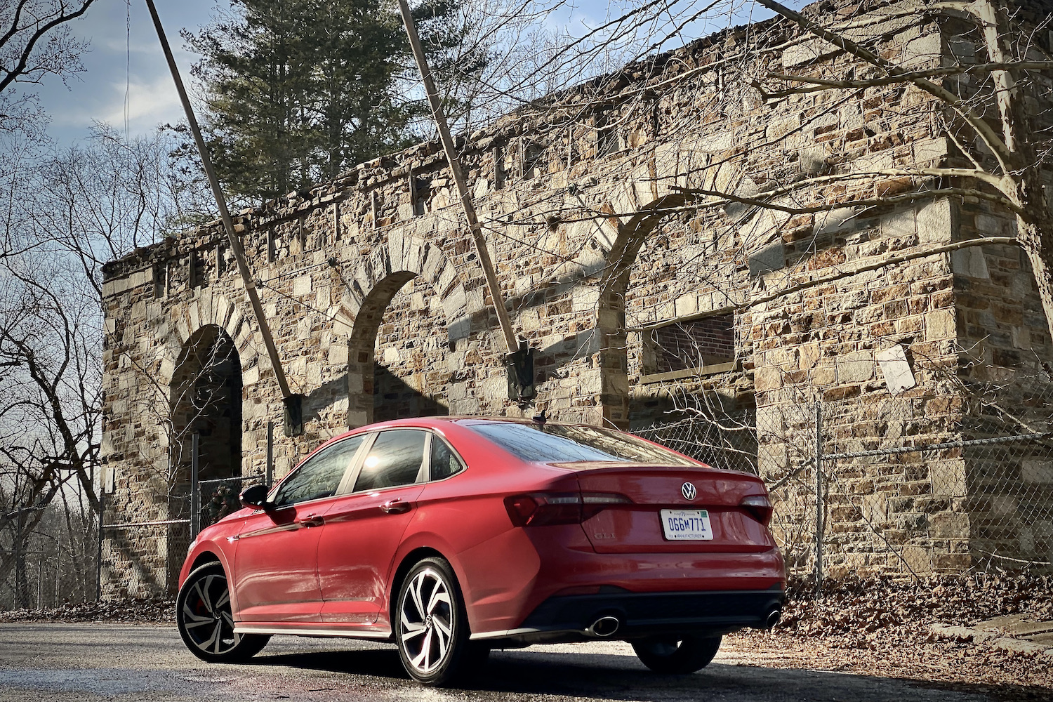 2022 Volkswagen Jetta rear end from driver's side in front of abandoned building.