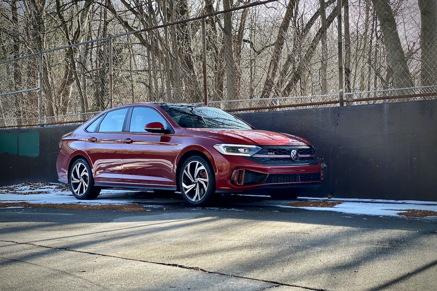 Front side profile of 2022 Volkswagen Jetta GLI in a snowy parking lot.