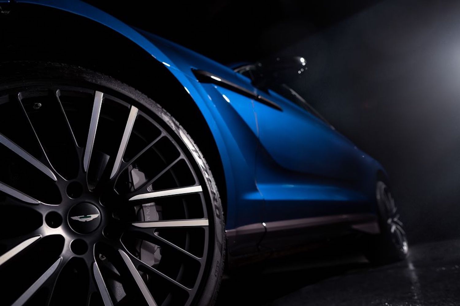 Close of up Aston Martin DBX 707 front wheel in a dark warehouse.