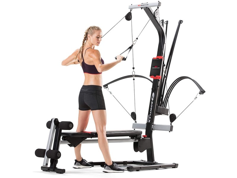 A woman working out using the Bowflex PR1000 Home Gym.