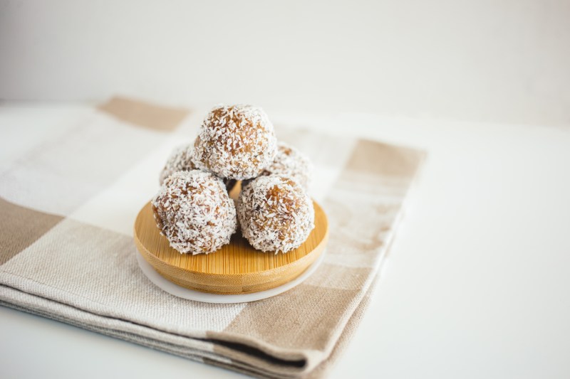 Kulki daktylowe na misce na ręczniku kuchennym.