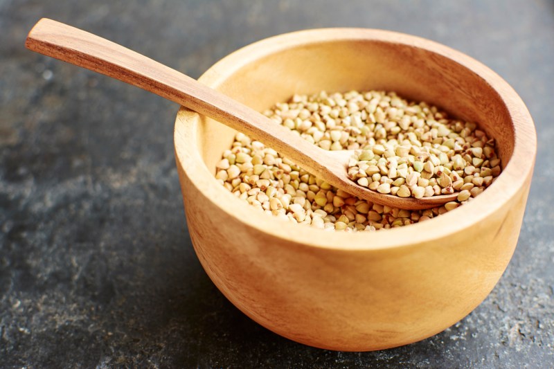 A wooden spoon in a bowl of hemp seeds.