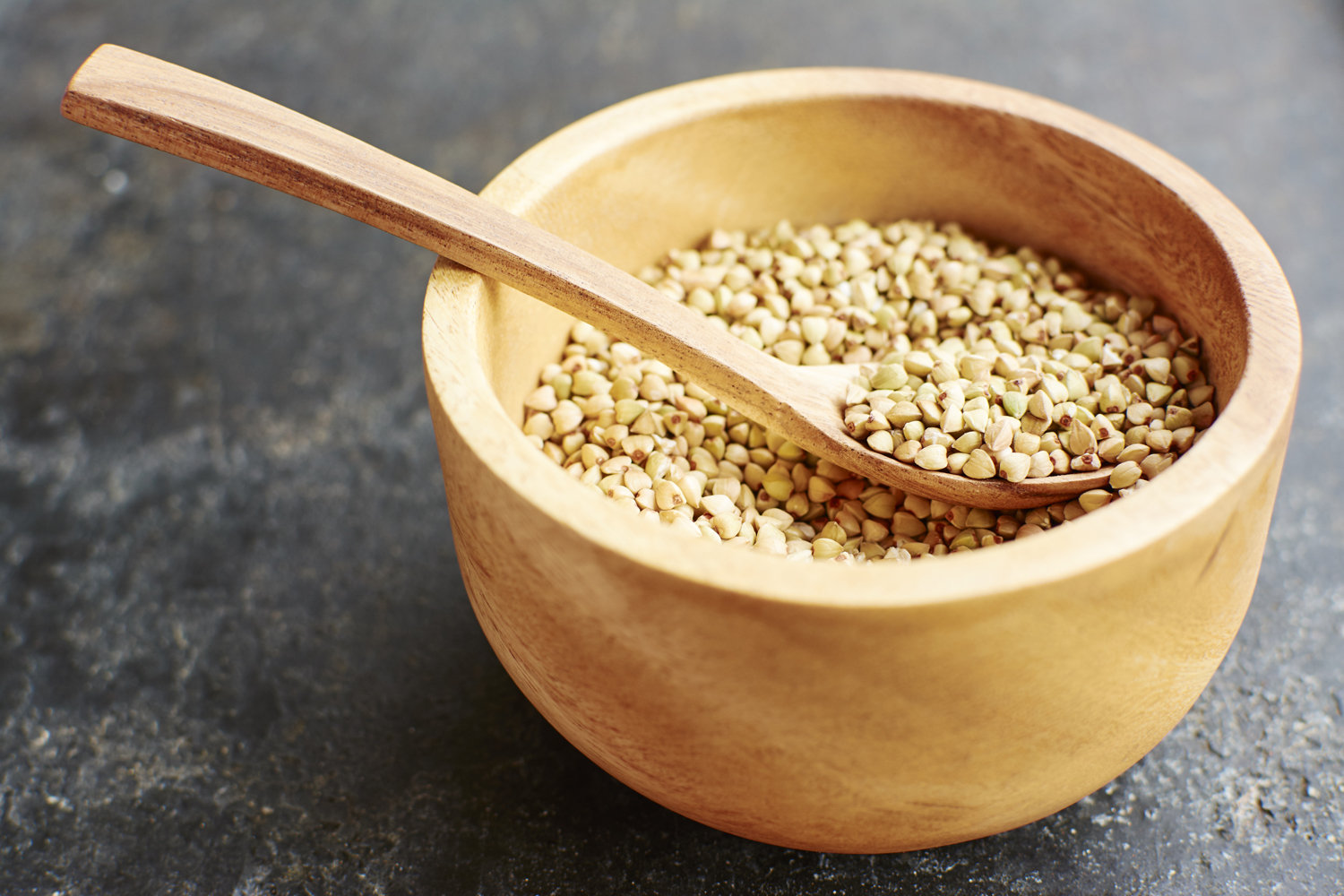 A wooden spoon in a bowl of hemp seeds.