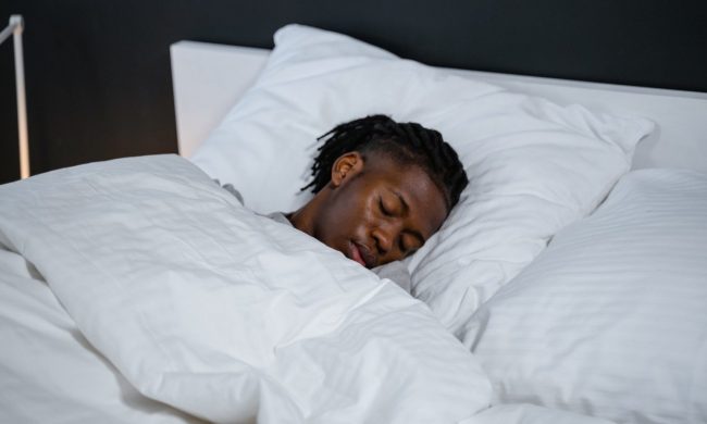 A man lies asleep in bed