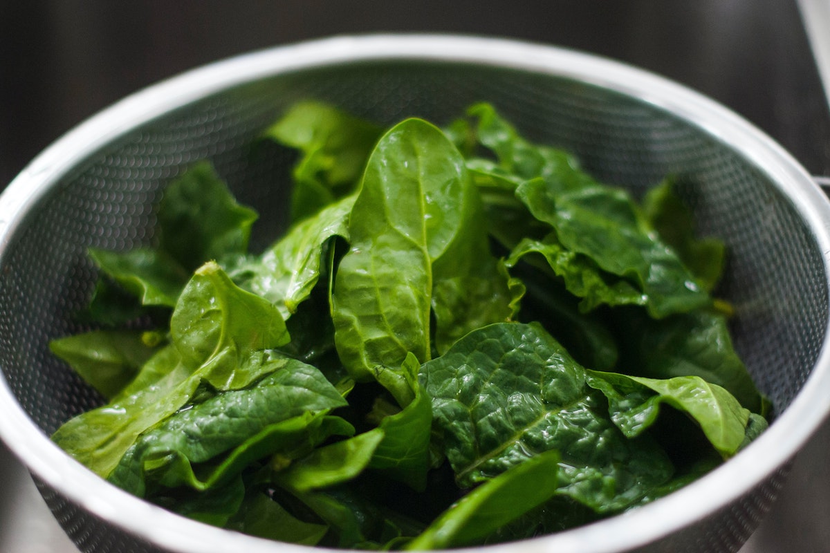 Green spinach leaves in a collander.