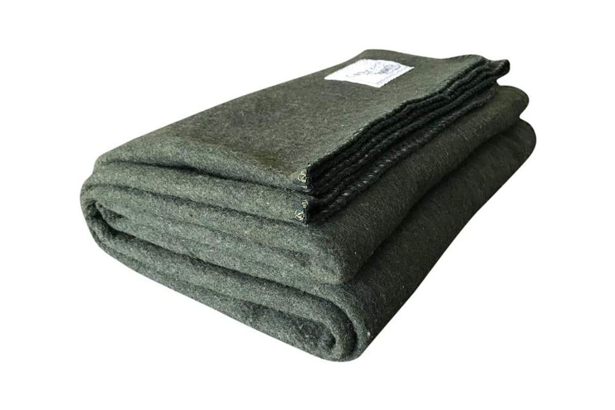 A folded woolen blanket in olive green from Woolly Mammoth on a white background