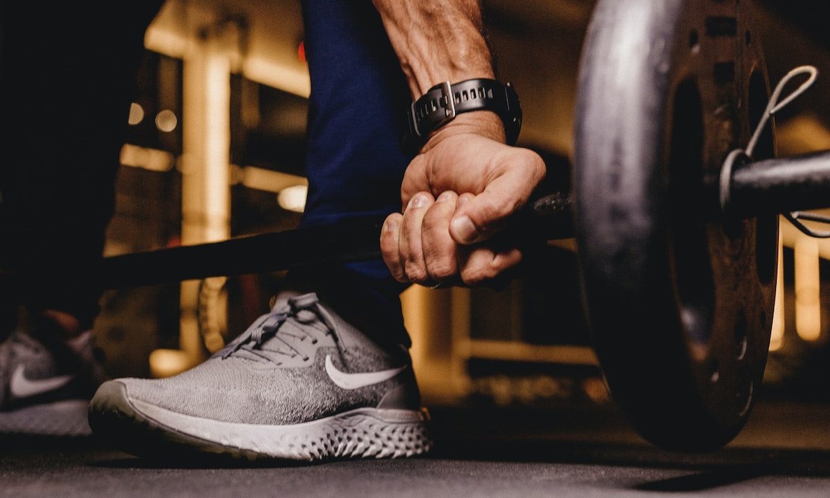 Man gripping a barbell to do a deadlift