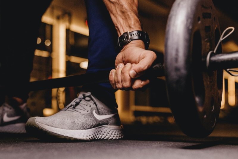 Man gripping a barbell to do a deadlift
