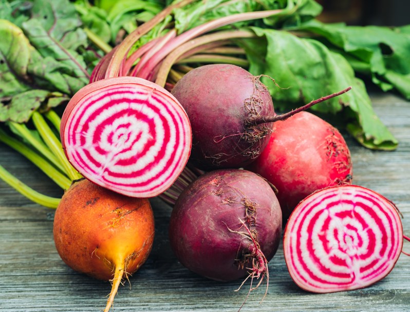 A close-up of fresh beets on wooden table.