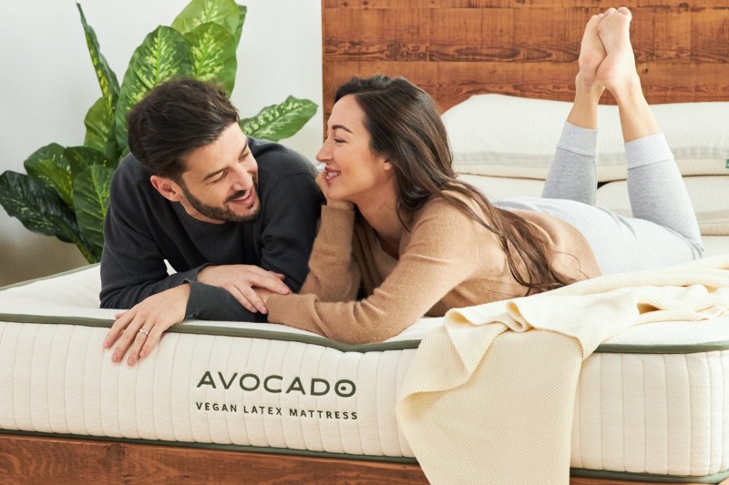 A couple lie on an Avocado Vegan Latex mattress.