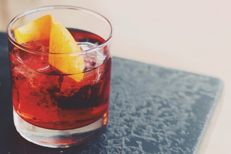 A glass of Boulevardier on a table.