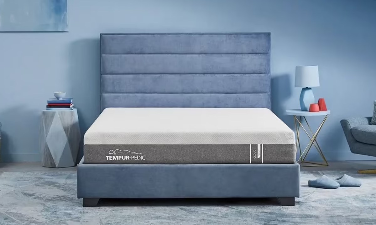 The Tempur-Pedic HERO Cloud mattress on a blue bed in a blue bedroom.