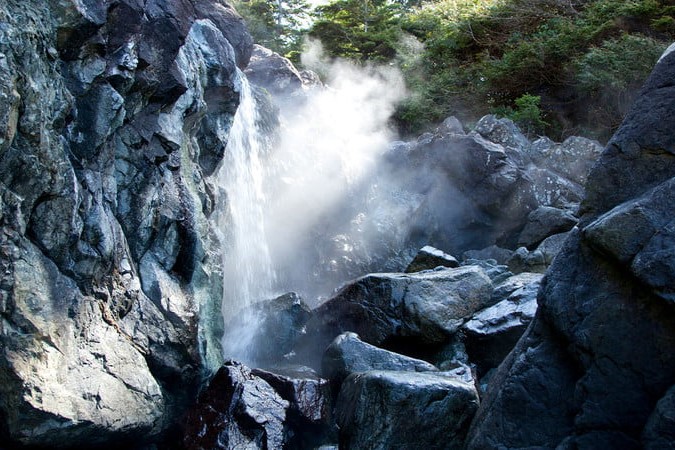 A hot springs cove, surrounded by lots of large grey rocks.
