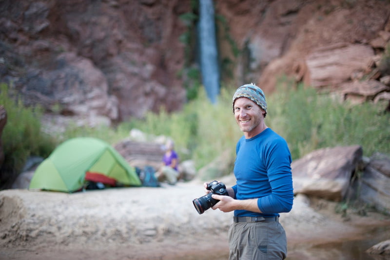 Man holding camera at a campsite