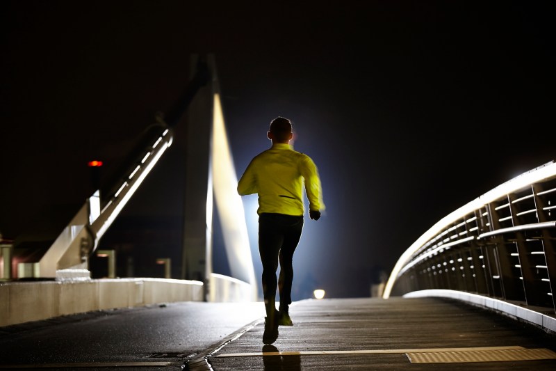 Man running along at night on a bridge