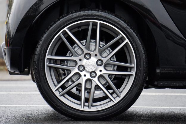 閃亮的汽車輪胎的特寫，帶有布拉布斯車輪在人行道上。