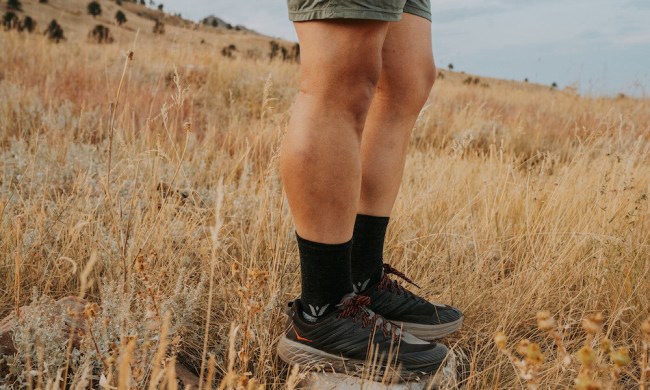 Man wearing swiftwick flite xt trail socks in a field.