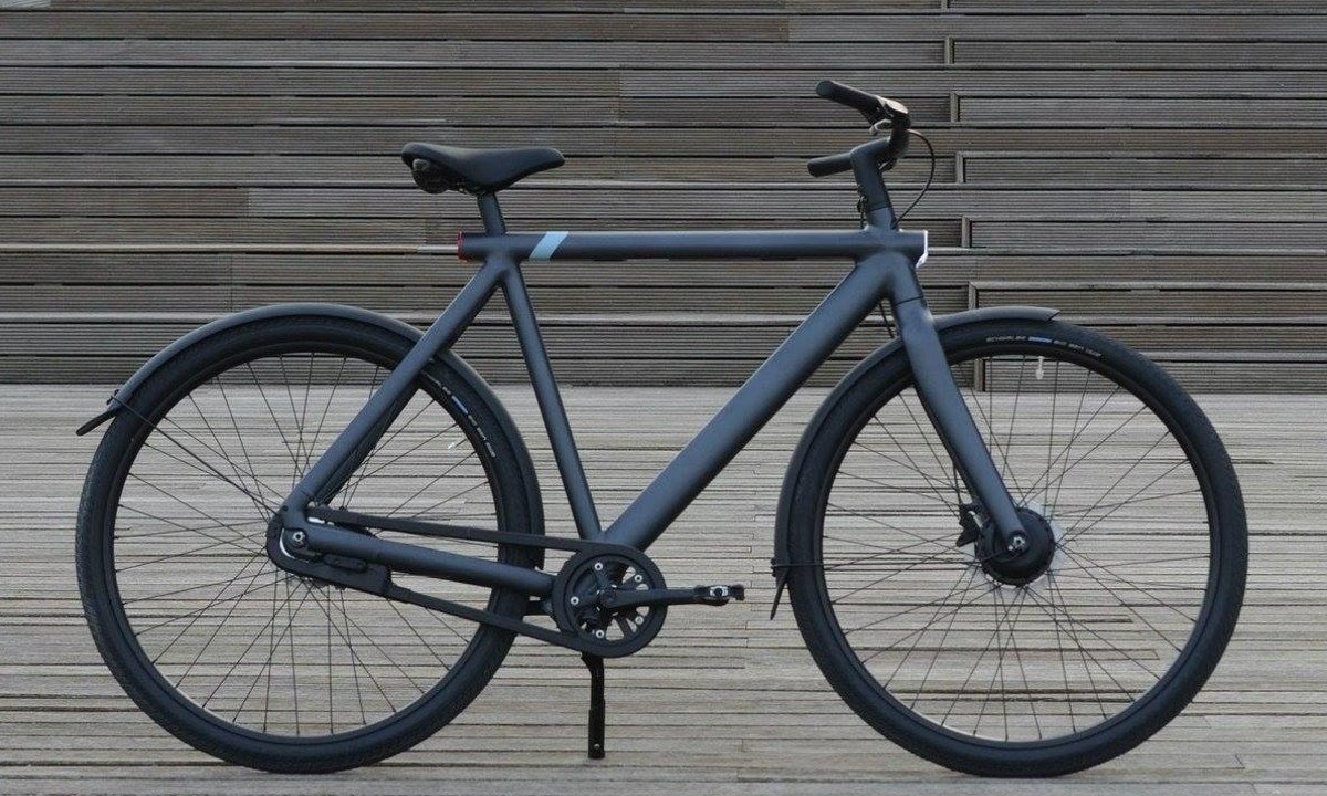 The VanMoof S3 ebike standing against some stairs.