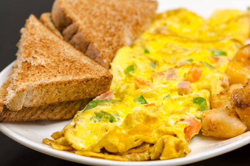 Una tortilla de verduras junto a sándwiches tostados en un plato.